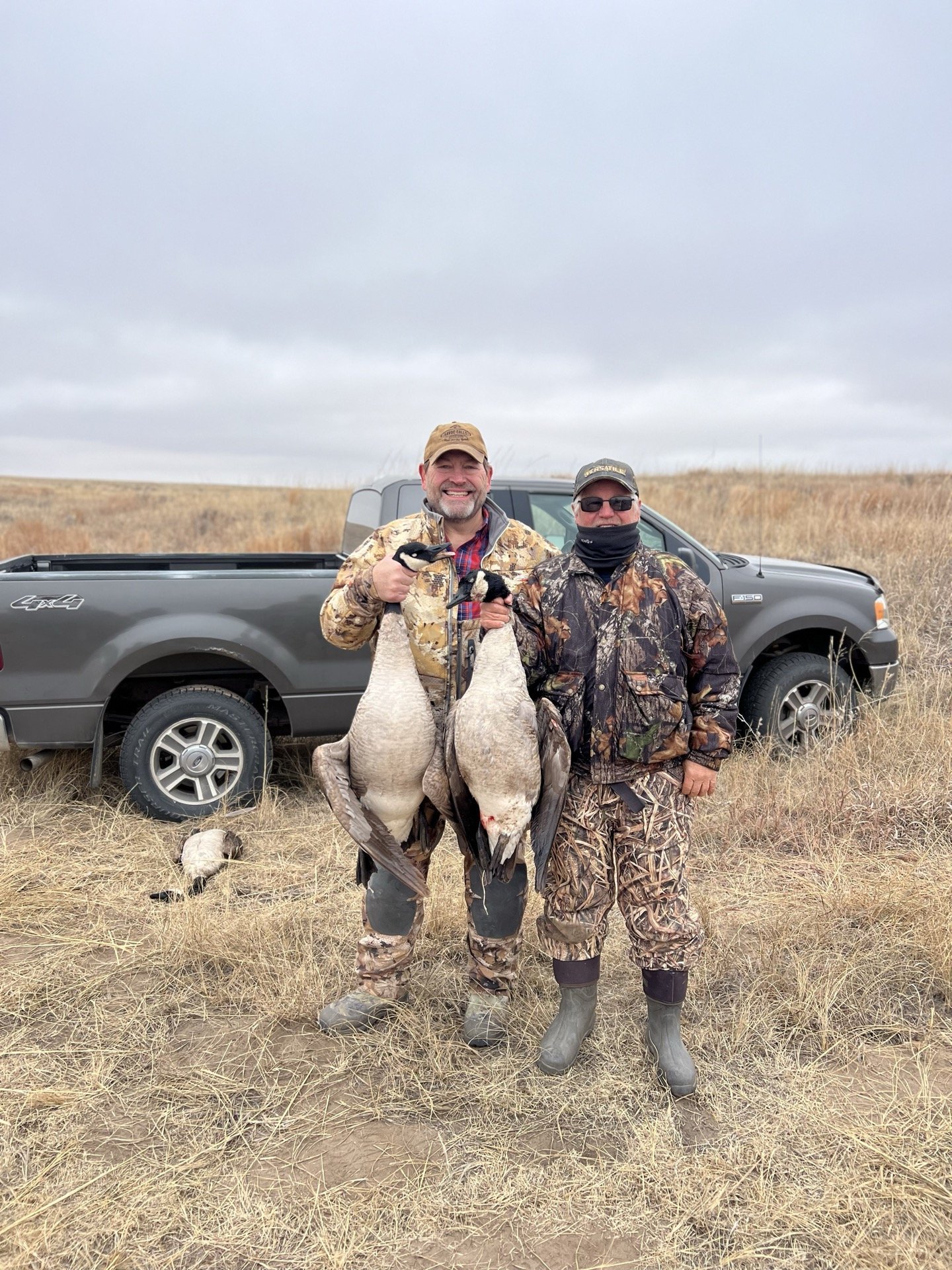 Craig Carson and Steve after a goose hunt by a pickup truck